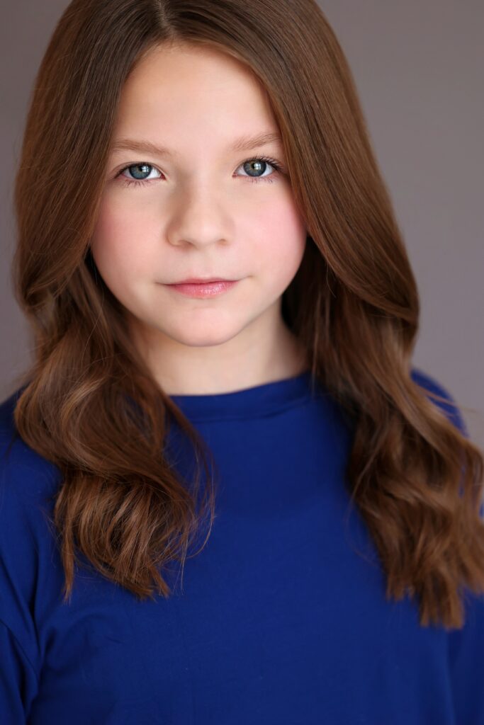 Emery Dunham, a young brunette girl wearing a blue sweater