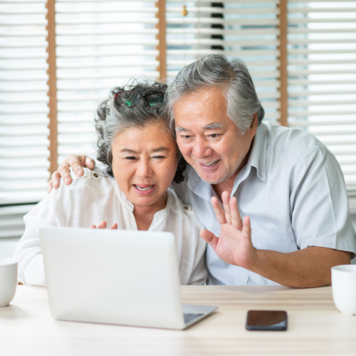 Picture of Asian grandparents looking at their laptop.